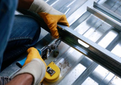 Manual worker with metal shears cutting sheet metal